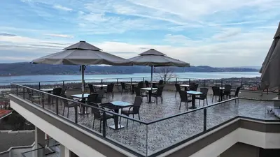 a balcony with tables and chairs and umbrellas at Best Western Plus Sapanca in Sapanca