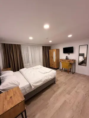 a bedroom with a bed and a desk and a television at Mütena konaklama in Mudanya