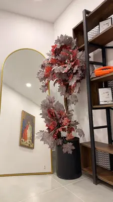 a black vase with a red plant in a room at Mütena konaklama in Mudanya