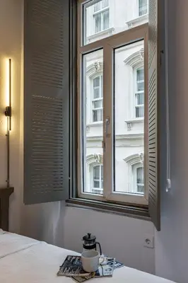 a bedroom with a window with a coffee cup on a table at Ganbaru Tours - Flats in Galata 2 in Istanbul