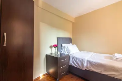 a bedroom with a bed and a dresser with flowers on it at Leafy Views & Light Filled Comfort in Kuzguncuk in Istanbul