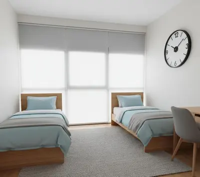 two beds in a room with a clock on the wall at Yeni Yıl Apart in Bandırma