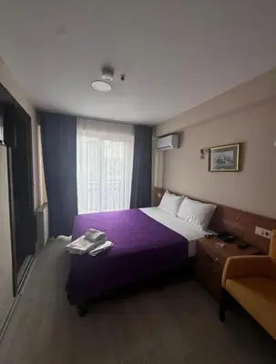 a hotel room with a purple bed and a window at grand life hotel in Corlu