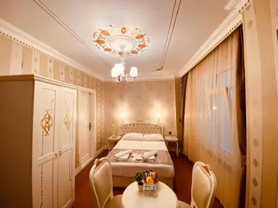 a bedroom with a bed and two tables and a chandelier at Hotel Alyon Beyoğlu in Istanbul