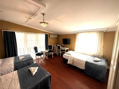 a hotel room with two beds and a table and chairs at Hotel Alyon Beyoğlu in Istanbul
