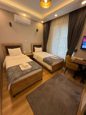 a hotel room with two beds and a desk and a piano at AYD Apartment Taksim in Istanbul
