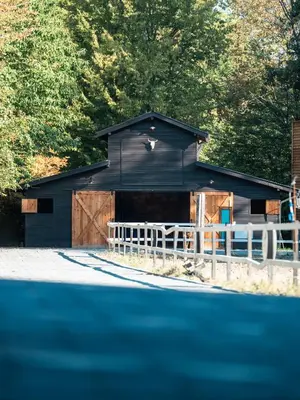 a black barn with a white fence in front of it at HARA Bıçkıdere in Akyazı