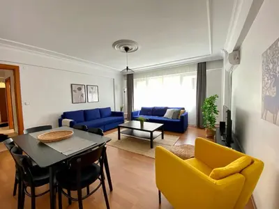 a living room with a table and yellow chairs at Central Location 3 Bedroom Flat - No6 in Istanbul