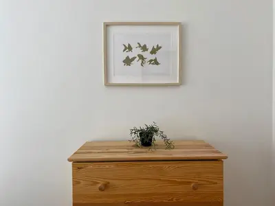 a picture hanging on a white wall above a wooden dresser at Central Location 3 Bedroom Flat - No6 in Istanbul