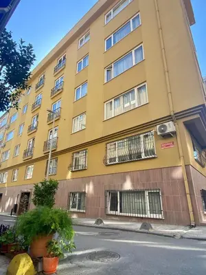 a yellow building with barred windows on a street at Central Location 3 Bedroom Flat - No6 in Istanbul