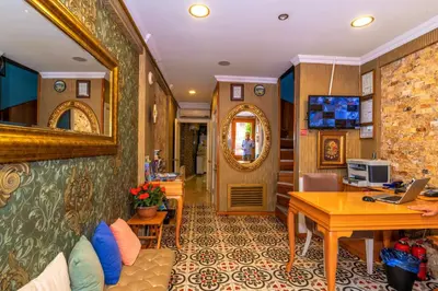 a living room with a desk and a table with a laptop at Walnut Shell Hotel in Istanbul