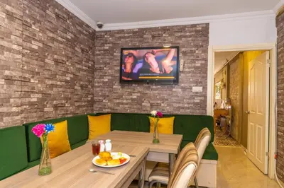 a dining room with a table and a television on the wall at Walnut Shell Hotel in Istanbul