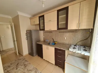 a kitchen with wooden cabinets and a stove and refrigerator at Specius Flat Near Yeditepe Univ in Istanbul