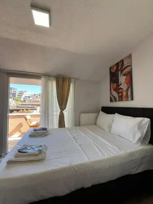 a bedroom with a large white bed with a window at Taksim Dolunay Suites in Istanbul