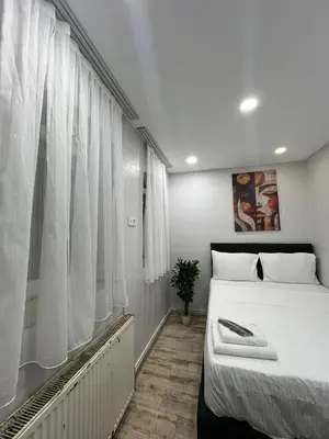 a bedroom with a large white bed and a window at Taksim Dolunay Suites in Istanbul