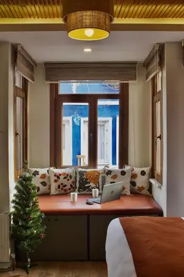 a bedroom with a laptop on a bench with a christmas tree at PeraHomes DE in Istanbul