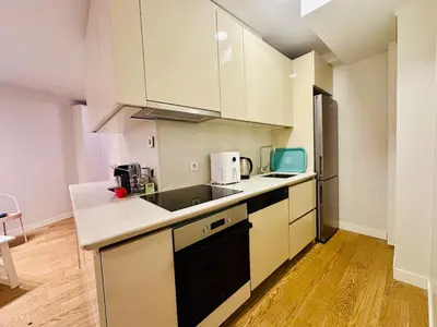 a kitchen with white cabinets and a sink and a refrigerator at Beyoglu Hacımimi Gardens içinde özel bahçeli daire in Istanbul
