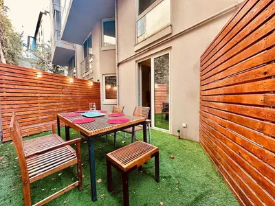 a patio with a table and two chairs and a fence at Beyoglu Hacımimi Gardens içinde özel bahçeli daire in Istanbul