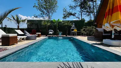 a swimming pool in a yard with chairs and an umbrella at Reborn sapanca in Sapanca