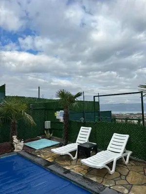 two white chairs sitting next to a swimming pool at Reborn sapanca in Sapanca