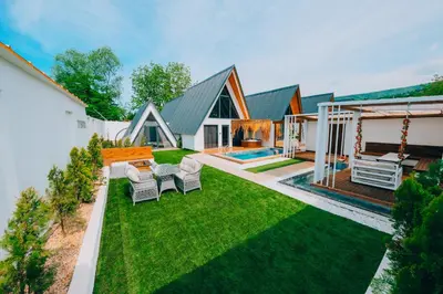 a backyard with a lawn with chairs and a house at 777Sapanca Bungalov Konaklama in Sapanca