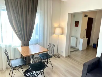 a dining table and chairs in a living room at Şeker Apartments in Tuzla
