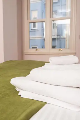 a bed with white sheets and a window at Galata Maison by Guest Teori in Istanbul