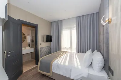 a bedroom with a large bed and a bathroom at Tumar Istanbul Hotel in Istanbul