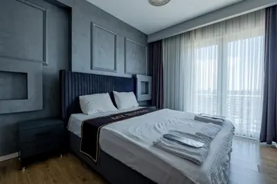 a bedroom with a bed and a large window at My SUİTES in Istanbul