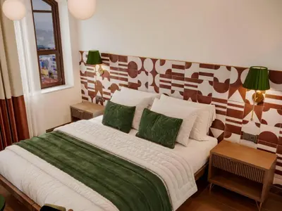 a bedroom with a large bed with green and white pillows at Castellion Hotels Galata in Istanbul