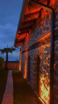 a stone building with fire on the side of it at Taş Devri Konaklama in İznik