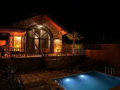 a swimming pool in front of a house at night at Taş Devri Konaklama in İznik