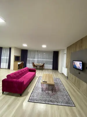 a living room with a red couch and a table at Luxury Suit