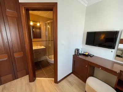 a hotel room with a bathroom with a television on the wall at Marmara Konak Old City in Istanbul
