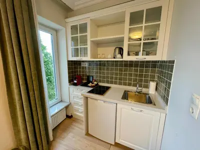 a kitchen with white cabinets and a sink and a window at Marmara Konak Old City in Istanbul