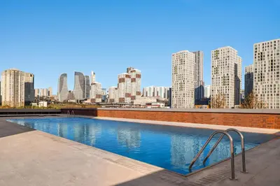 a swimming pool with a city skyline in the background at Ramada Residences by Wyndham Istanbul Haramidere in Istanbul