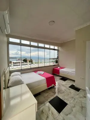 a bedroom with two beds and a large window at Grand Şakar Otel in Marmara