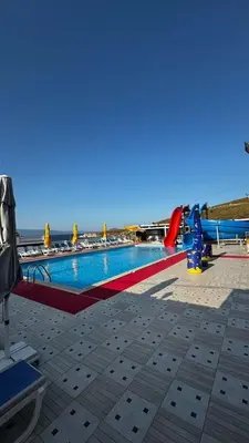 a large swimming pool with the ocean in the background at Grand Şakar Otel in Marmara