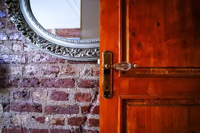 an open door with a mirror on a brick wall at İstanbul Galata Squit Apartments in Istanbul