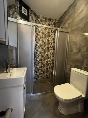 a bathroom with a shower and a toilet and a sink at Do Not Disturb Suites in Istanbul