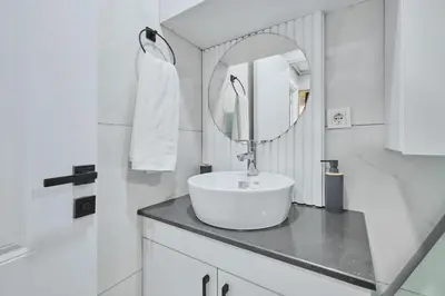 a white bathroom with a sink and a mirror at Ulker Apartments in Istanbul
