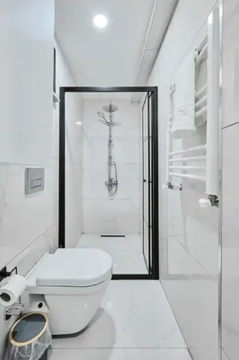 a white bathroom with a shower and a toilet at Ulker Apartments in Istanbul