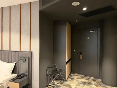 a bedroom with a bed and a door and a room at H-mak AIRPORT OTEL in Arnavutköy