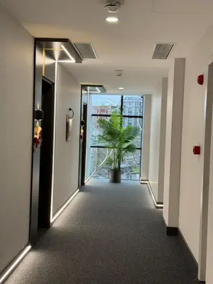 a hallway in an office building with a potted plant at H-mak AIRPORT OTEL in Arnavutköy