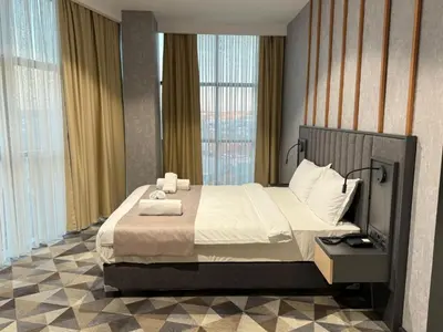 a bedroom with a large bed and a large window at H-mak AIRPORT OTEL in Arnavutköy