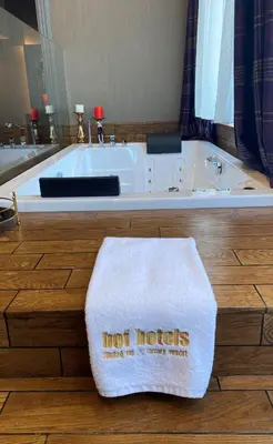a white bath tub with a hot words towel on the floor at Bof Hotels Uludağ Ski&Luxury Resort All Inclusive in Uludag