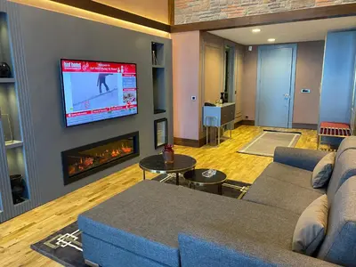 a living room with a couch and a tv on a wall at Bof Hotels Uludağ Ski&Luxury Resort All Inclusive in Uludag