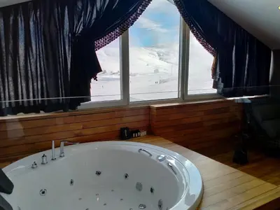 a bath tub in a room with a large window at Bof Hotels Uludağ Ski&Luxury Resort All Inclusive in Uludag