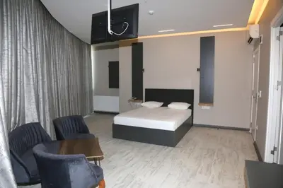 a bedroom with a bed and two chairs and a table at Zoom Airport Hotels in Istanbul