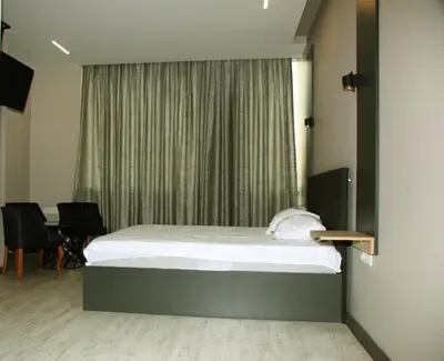 a bedroom with a bed and a window with chairs at Zoom Airport Hotels in Istanbul